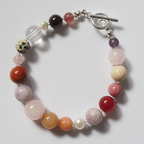 Each One Amelie Bracelet: Mixed natural gemstones including Jasper, Fossil, Quartz, Jade, Garnet, Rose Quartz, Amethyst, and Pearl with toggle closure.