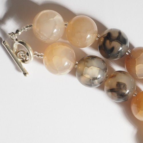Each One Kai Necklace: Dyed agate beads in cream, tan, and grey with unique markings, sterling silver toggle clasp, approx. 42cm.